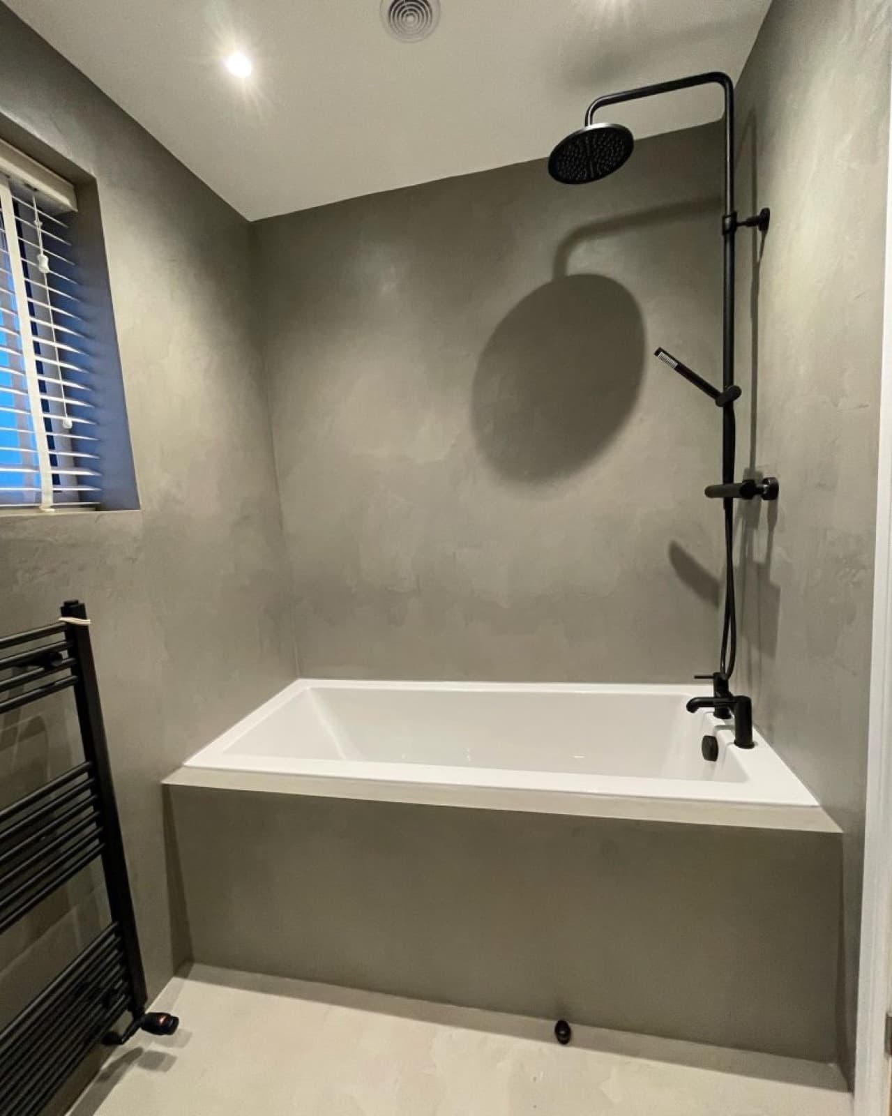 Microcement bathroom walls, worktop and floor in a warm neutral tone